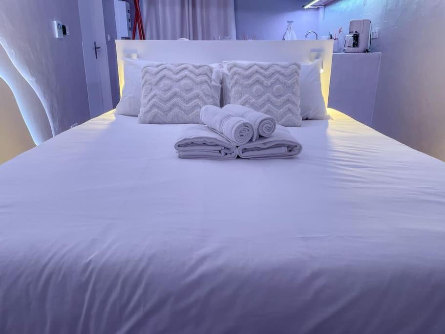 a white bed with two towels on top of it at À la folie - Loft &amp; Spa in Montrevault