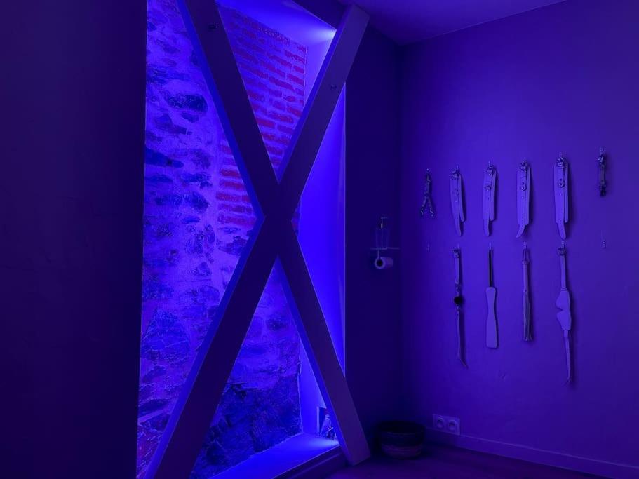 a purple room with a group of umbrellas on the wall at À la folie - Loft &amp; Spa in Montrevault