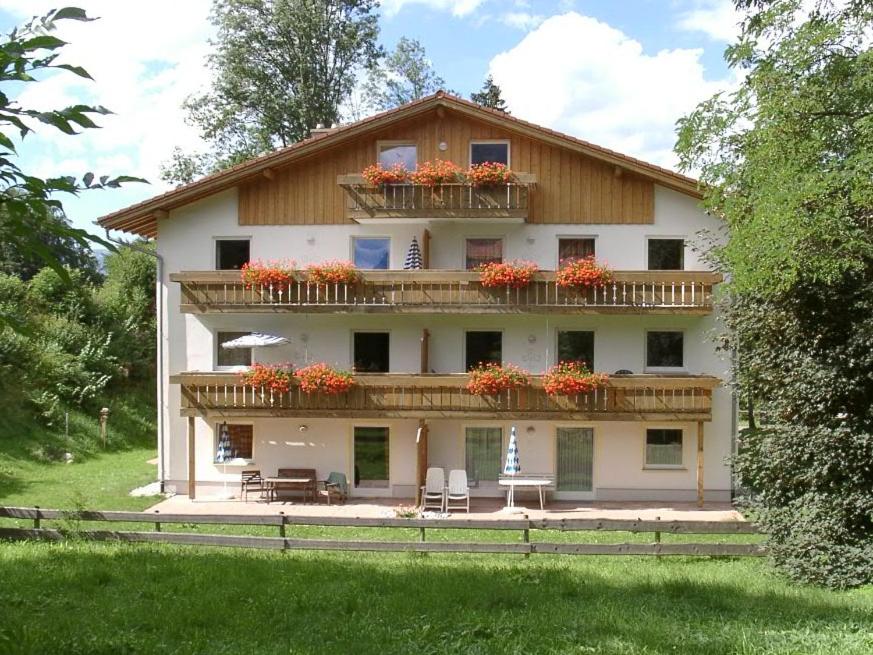 ein Gebäude mit zwei Balkonen mit Blumen darauf in der Unterkunft Ferienwohnung am Mühlbach 21 mit Bergbahn unlimited in Oberstdorf