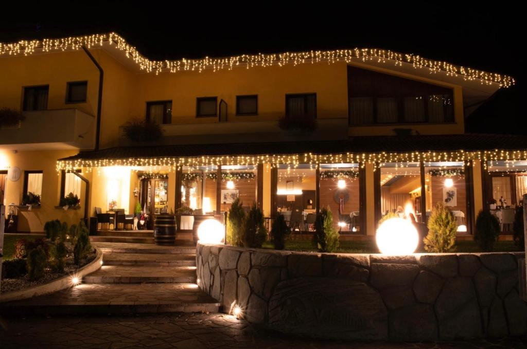 a building decorated with christmas lights at night at Casa Valcellina Hotel Ristorante in Montereale Valcellina