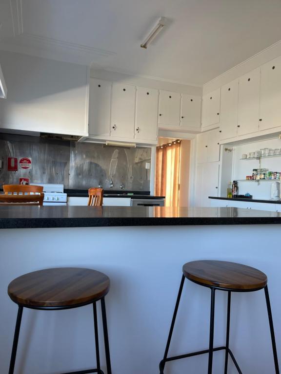 uma cozinha com dois bancos de bar num balcão em Apartment 1 on Oxide em Broken Hill