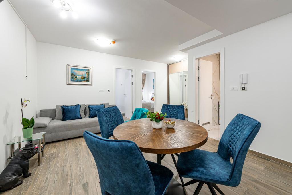 ein Wohnzimmer mit einem Holztisch und blauen Stühlen in der Unterkunft Lupo Gravosa FREE PARKING in Dubrovnik