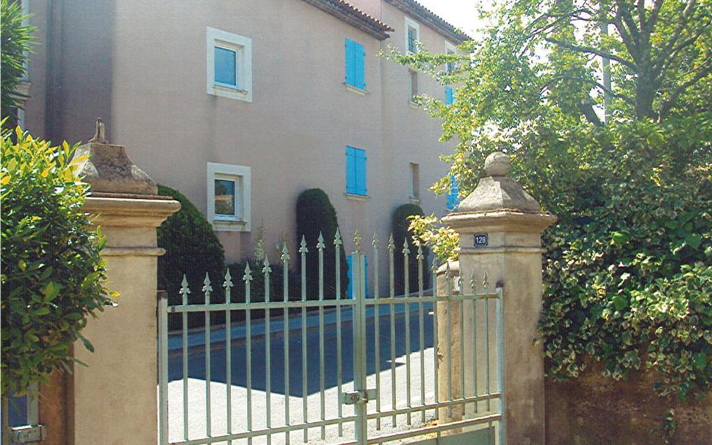 une clôture devant une maison avec des fenêtres bleues dans l'établissement Gîte Naphina, mer à 2.5 km, à La Croix-Valmer