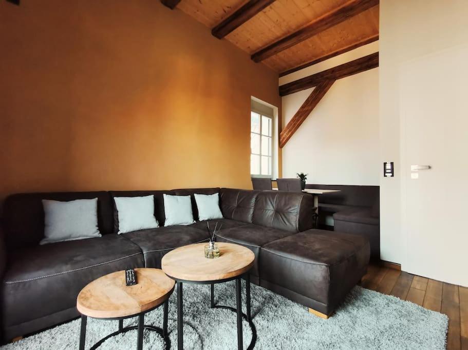 a living room with a leather couch and two tables at Komfortables Apartment im Zentrum Erfurts in Erfurt