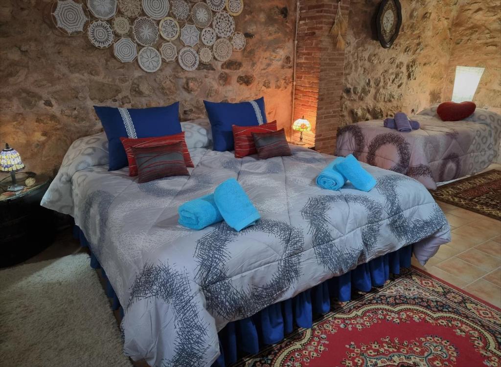 Un dormitorio con una cama con almohadas azules. en Vivelorural, en Cuevas Labradas