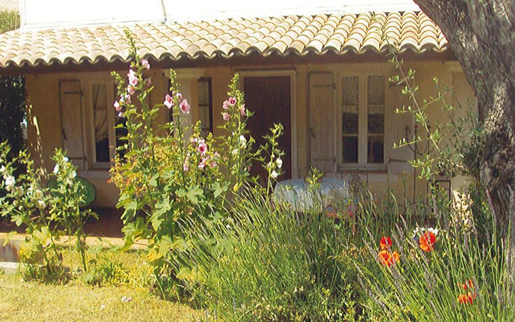 une petite maison avec des fleurs devant elle dans l'établissement Lei bugadiero, à La Croix-Valmer
