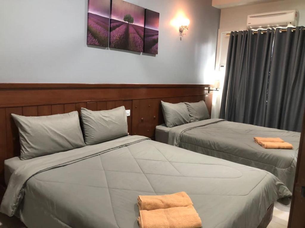 two beds in a hotel room with towels on them at L23 ,88 Resort Villa House in Pangkor