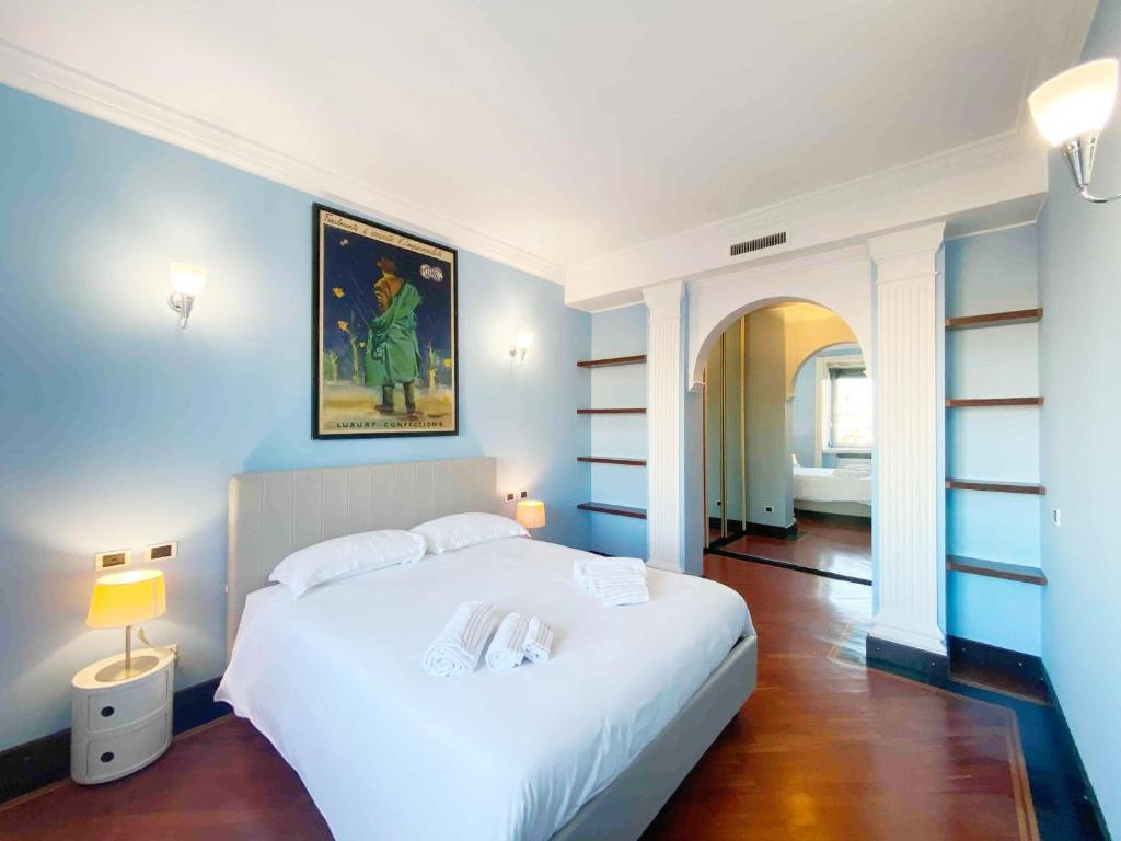 een slaapkamer met een groot wit bed en blauwe muren bij Penthouse Stefini 2 in Milaan