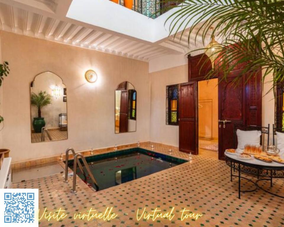 a swimming pool in a large room with a table at Riad Privé Dar L'Étoile - Piscine & Petit Déj inclus in Marrakesh