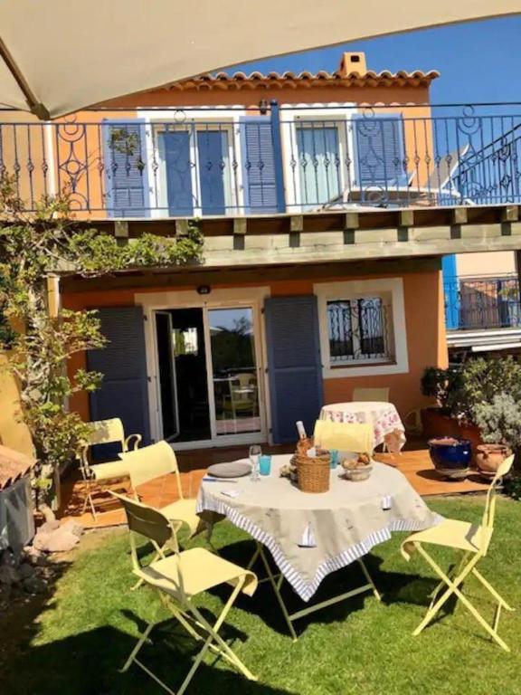 un patio avec une table et des chaises devant une maison dans l'établissement Villa la provencale, à Roquebrune-sur Argens