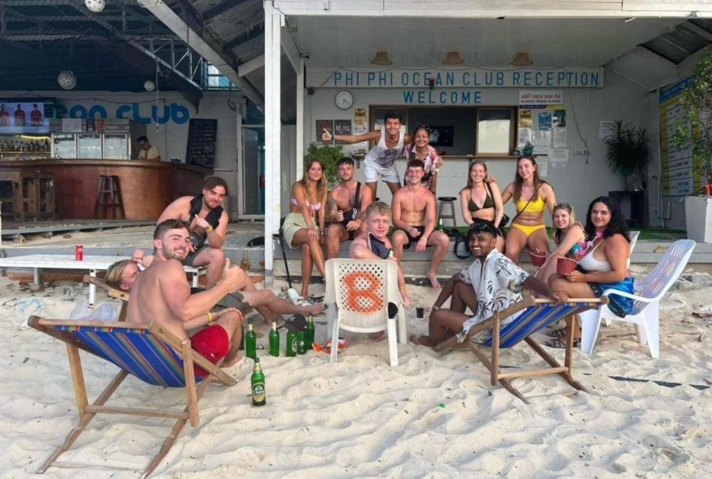 een groep mensen die in stoelen op het strand zitten bij Phi Phi Ocean Club in Phi Phi Don