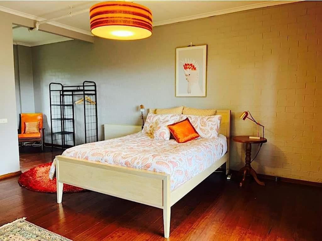 Dormitorio con cama con almohada naranja en Treetops apartment for 2, en Silvan