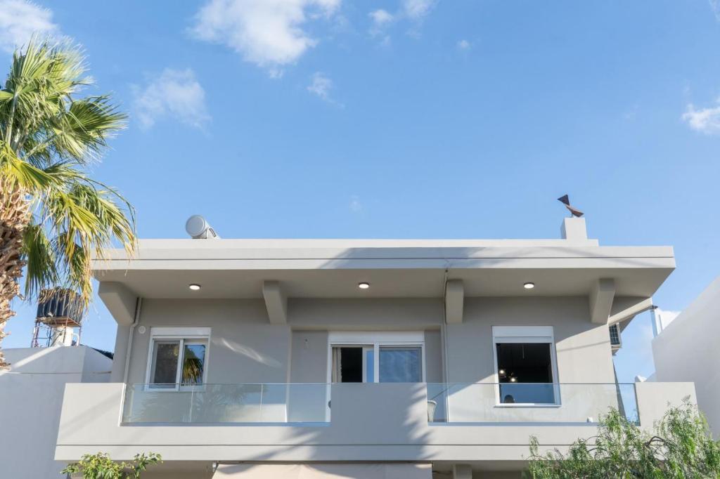 ヘルソニソスにあるNisimos Modern Apartmentのヤシの木のある白家