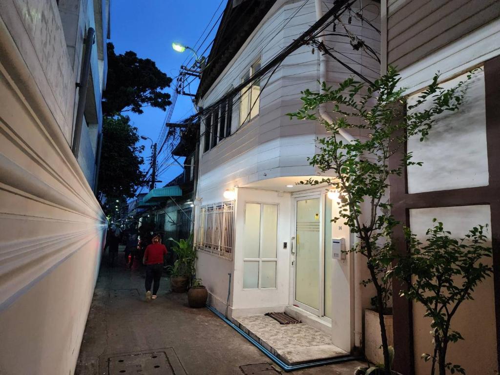 a person walking down a street next to a building at Green Apple Hostel Khaosan in Bangkok