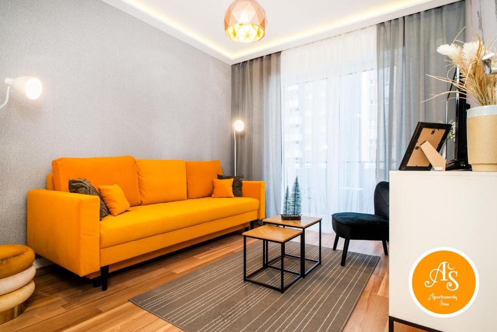 a living room with an orange couch and a table at ApartamentySnu, Wola Komfort IV z parkingiem in Warsaw