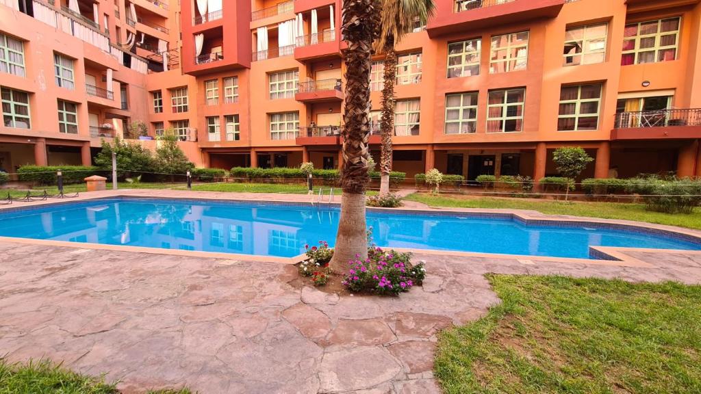 a swimming pool in front of a large apartment building at Apartamento en Majorelle, Marrakech. in Marrakesh