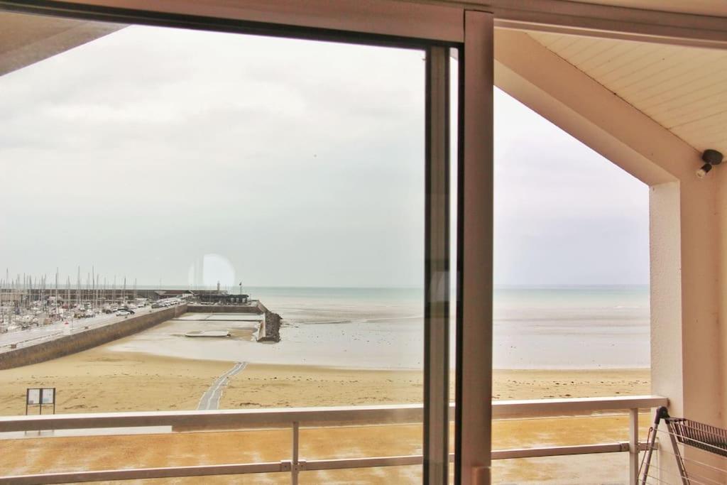 vistas a la playa desde la ventana de una casa en Un cocon au bord de l'eau, en Binic