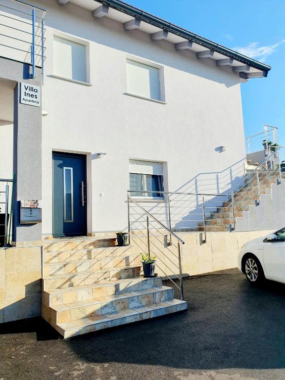 a white house with a blue door and stairs at Apartments Villa Ines Skofije -near Koper in Zgornje Škofije