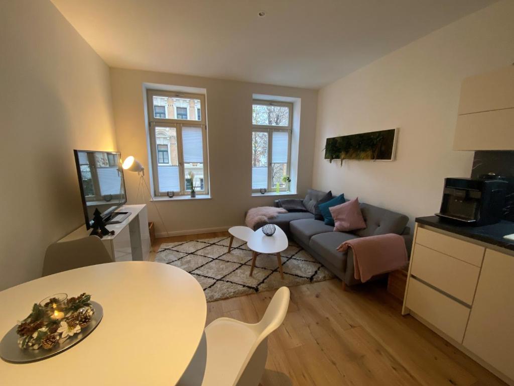 ein Wohnzimmer mit einem Sofa und einem Tisch in der Unterkunft Ferienwohnung Lipsia in Leipzig