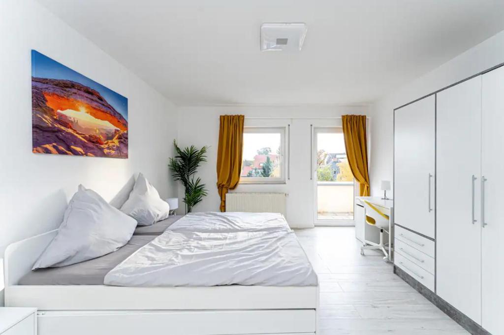 Habitación blanca con cama y escritorio en Grand Appartement nahe Müggelsee en Berlín