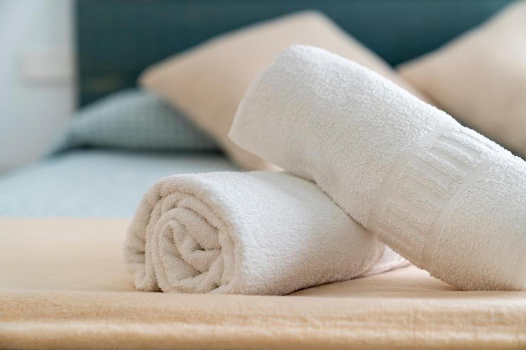 a white rolled up towel on a bed at El SUEÑO DE LA MANCHA in Mota del Cuervo