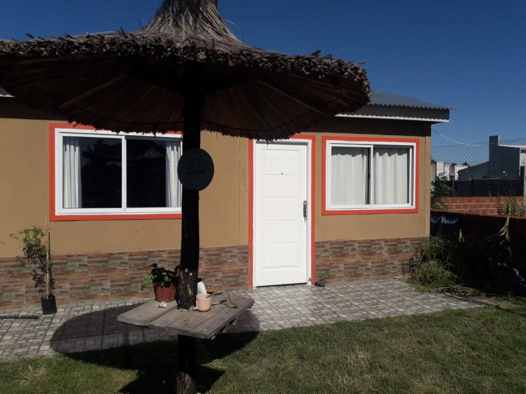 una casa con una puerta blanca y una sombrilla en La Delia en Gualeguaychú