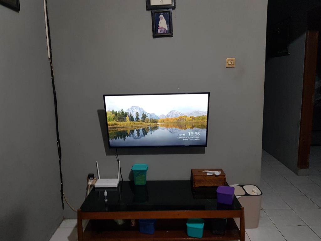 einen Flachbild-TV an der Wand in der Unterkunft Loot's house in Kalianget