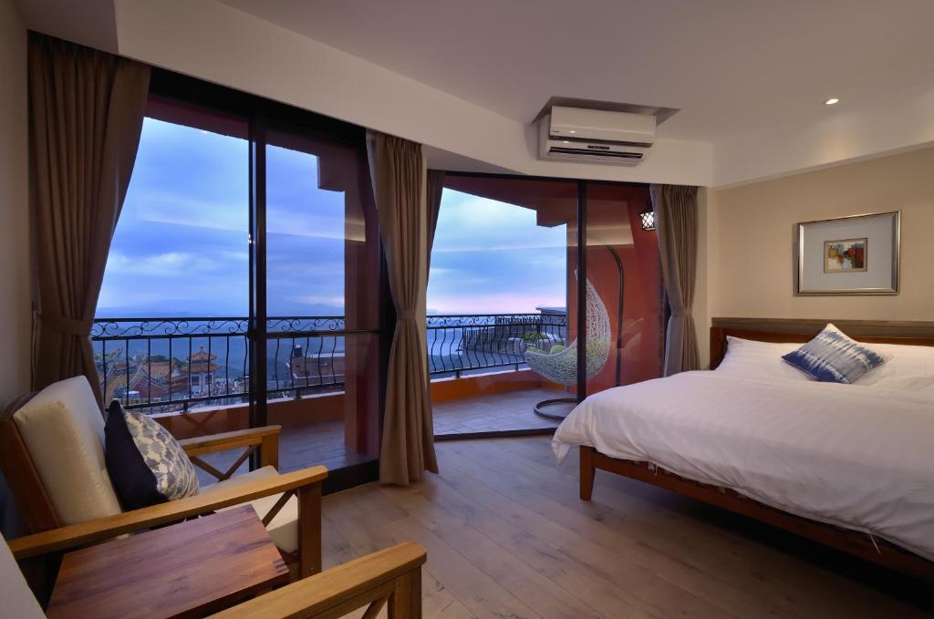 - une chambre avec un lit et un balcon dans l'établissement Sunshine B&B, à Jiufen