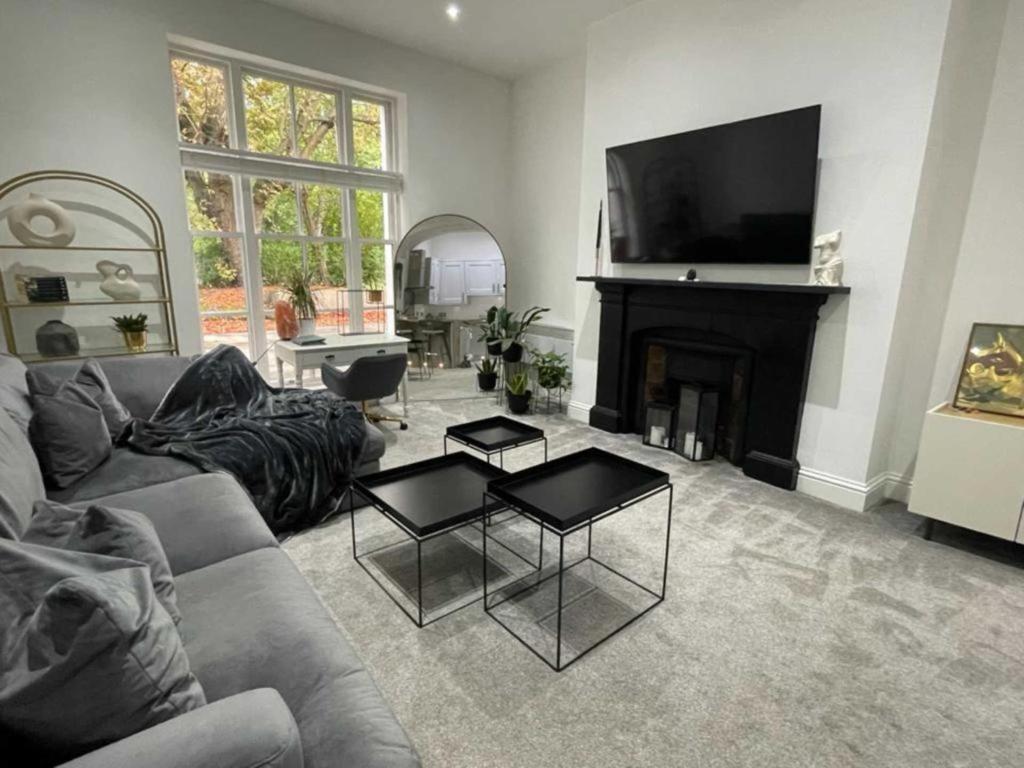 a living room with a couch and a fireplace at Orange Rentals- Cosy Apartment- Free Parking! in Liverpool