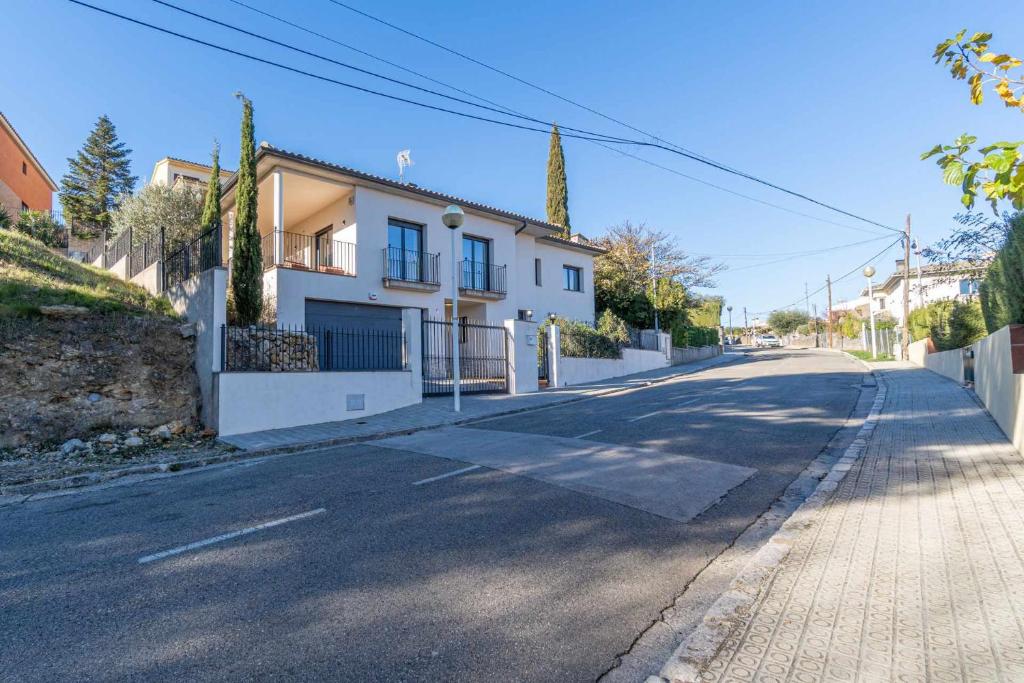 una strada vuota con una casa sul ciglio della strada di Jouvacations Villa Domenec a Figueres