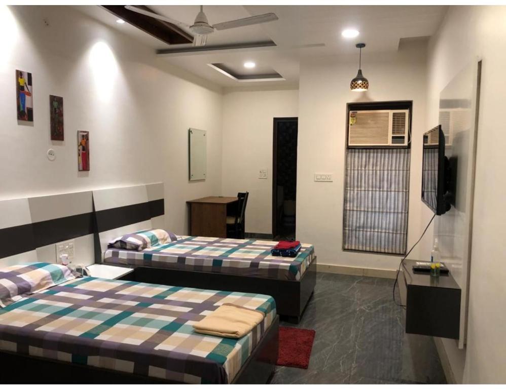 Habitación con 2 camas y TV. en V Guest House, Ludhiana, en Ludhiana