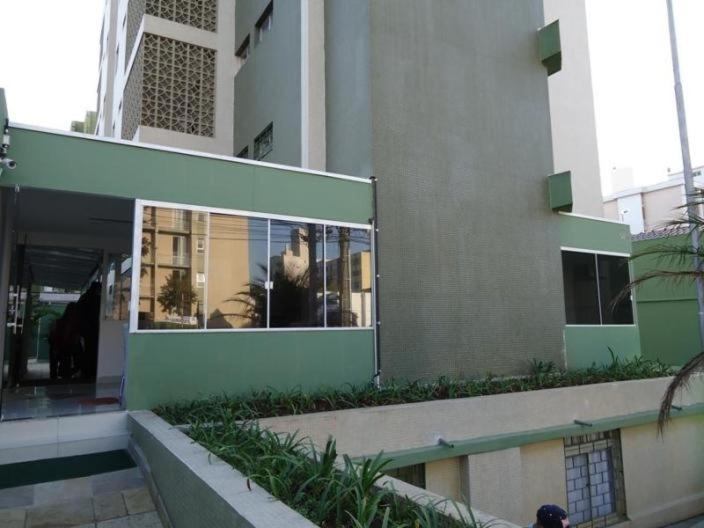 un edificio con ventanas y plantas delante de él en Apartamento Juvevê., en Curitiba