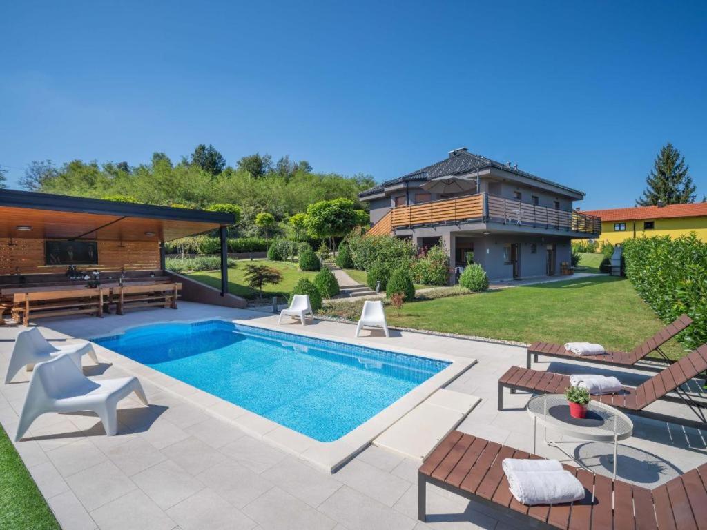 a backyard with a swimming pool and a house at Mala kuća Mia in Bosiljevo