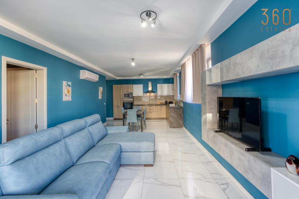 uma sala de estar com paredes azuis e um sofá azul em Relaxing 2BR home with Private Balcony in Mellieha by 360 Estates em Mellieħa