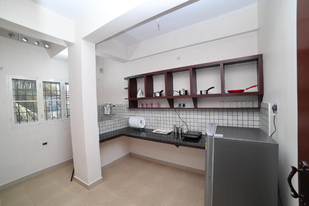 a kitchen with white walls and a black counter at Indeevaram Residency in Trivandrum