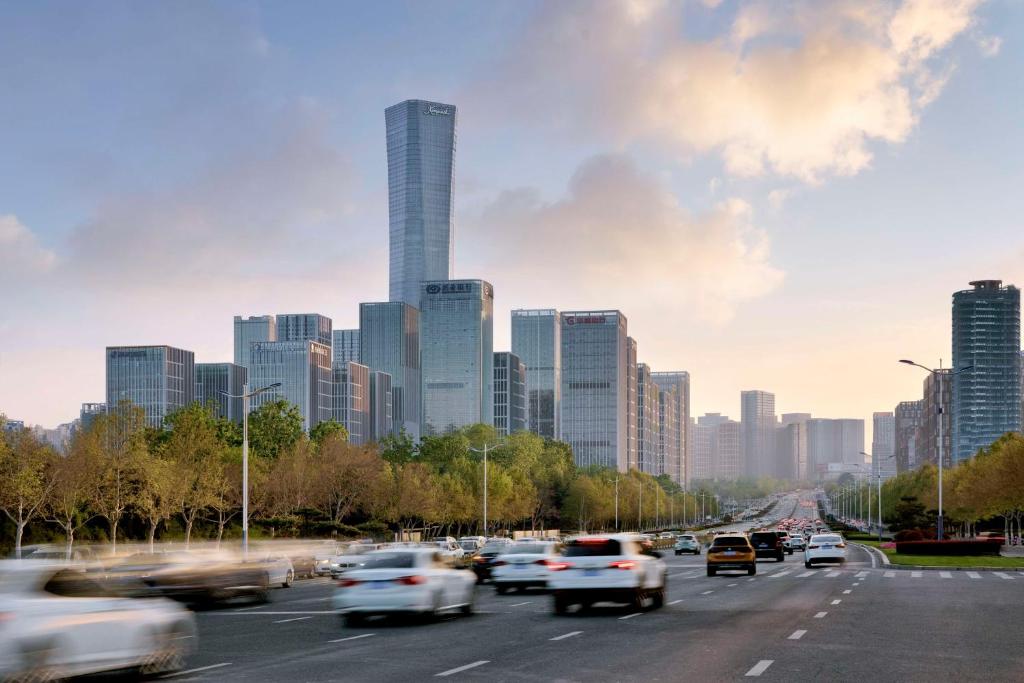 ruchliwa autostrada z ruchem w mieście z wysokimi budynkami w obiekcie Kempinski Hotel Jinan w mieście Jinan