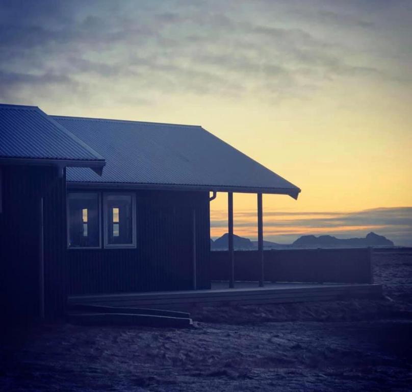 una casa con la puesta de sol en el fondo en Bryggjur, en Hvolsvöllur