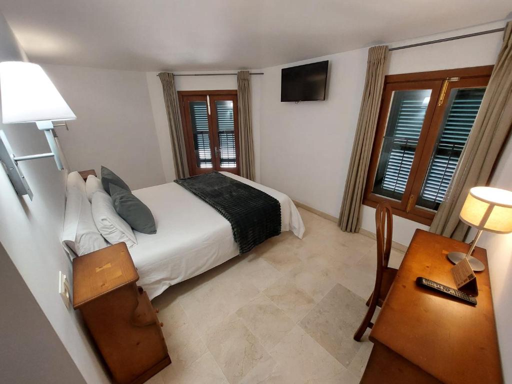 um quarto com uma cama e uma mesa com um candeeiro em My Rooms Manacor Centre by My Rooms Hotels em Manacor