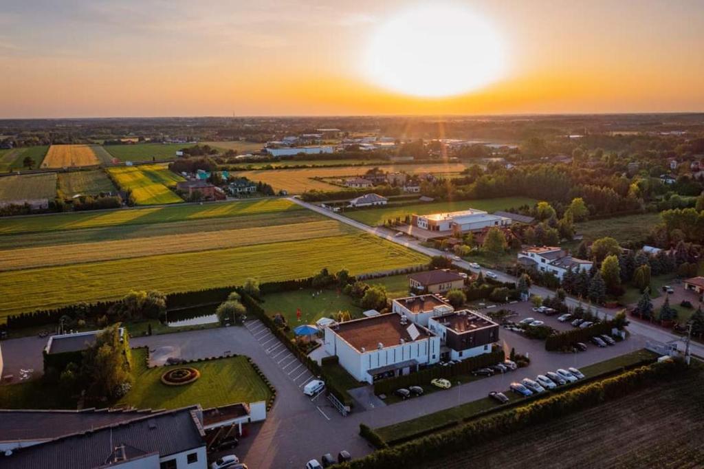 an aerial view of a building with the sunset in the background at Hotel Eden in Rzgów