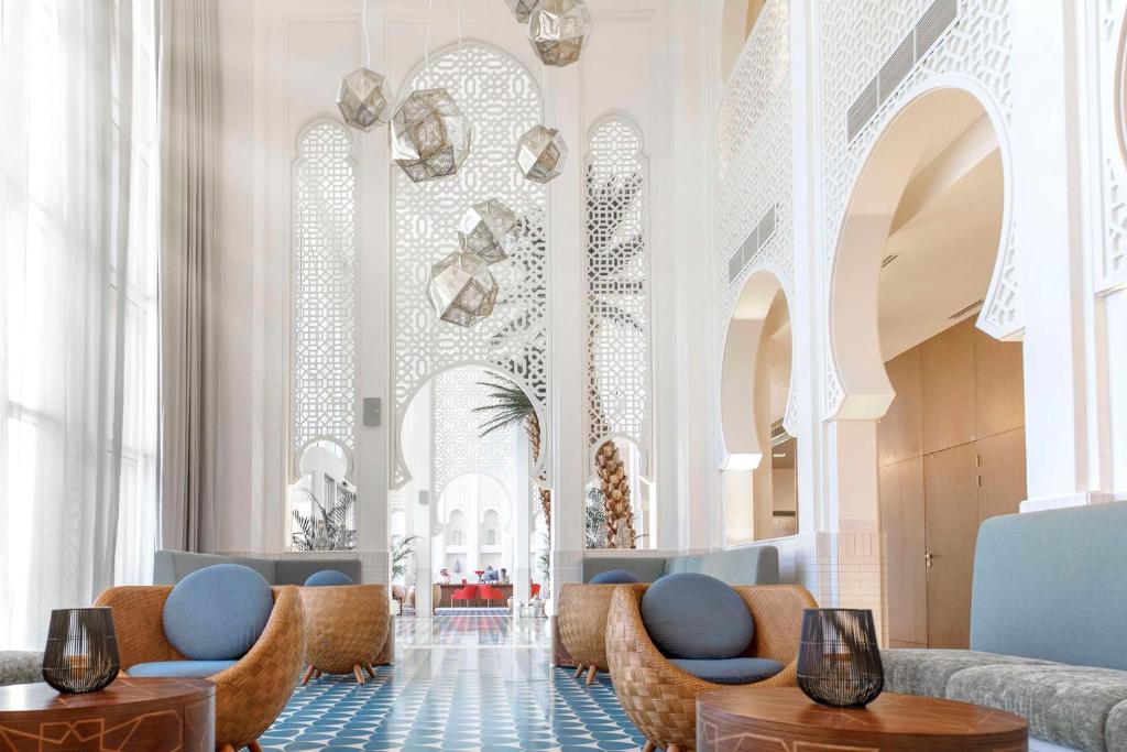 a lobby with blue chairs and white ceilings at Shaza Riyadh in Riyadh