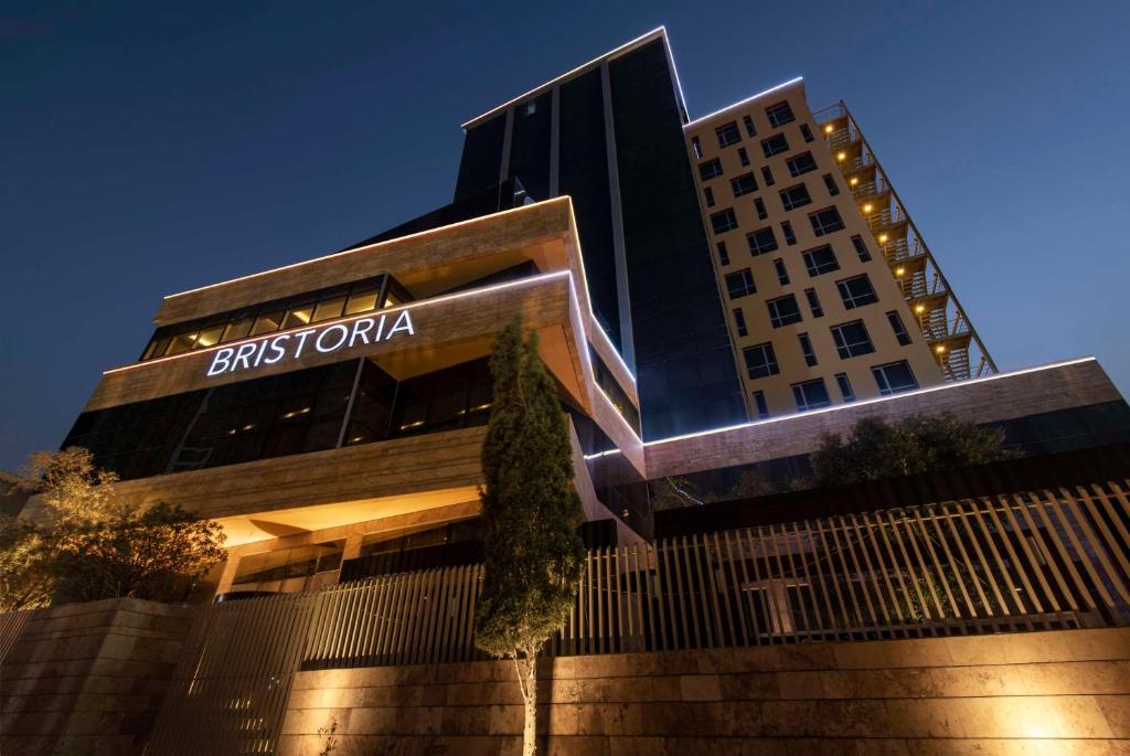 a building with a sign on the side of it at Bristoria Hotel Erbil in Erbil