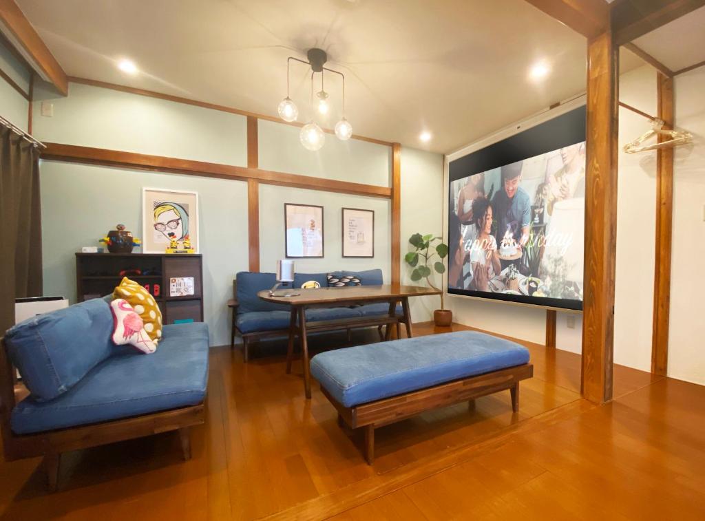 a living room with a blue couch and a table at TABISAI HOTEL House 博多 in Fukuoka