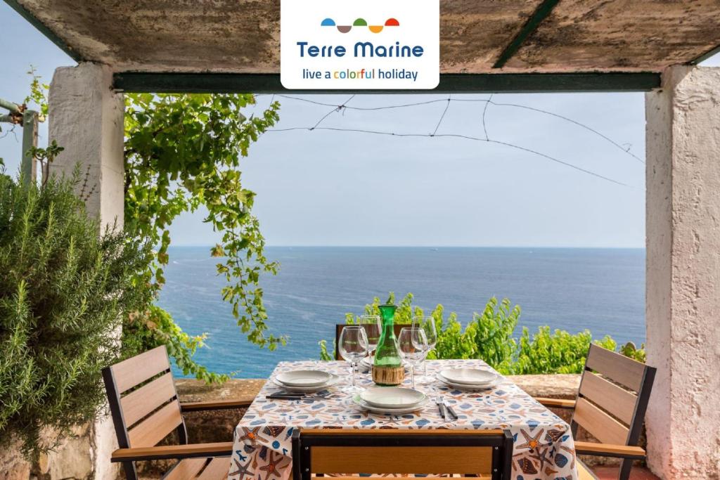 a table with chairs and a sign that readsete maurice overlooking the ocean at Casa Luciana, TerreMarine, Trekking and Nature in La Spezia