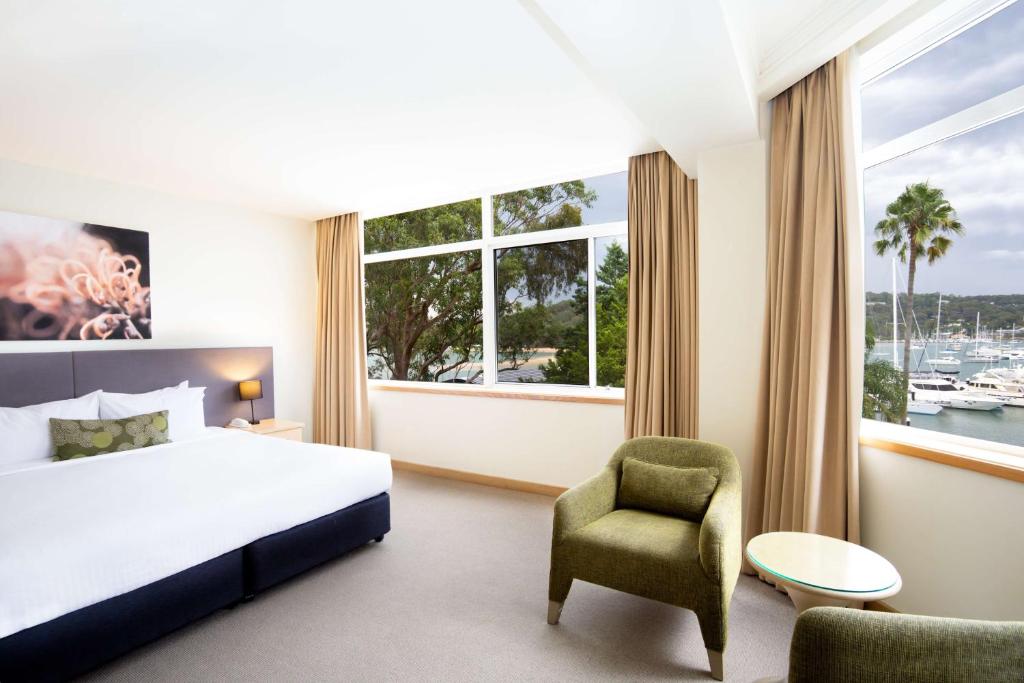 Habitación de hotel con cama, silla y ventana en Metro Mirage Hotel Newport en Newport