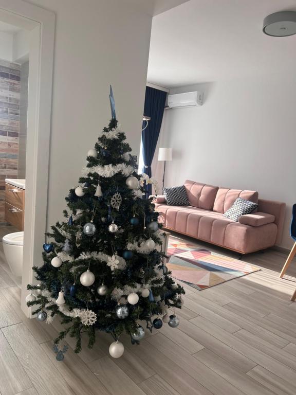 a christmas tree in a living room with a couch at Karra Residence Timisoara - autorizat Ministerul Turismului in Timişoara