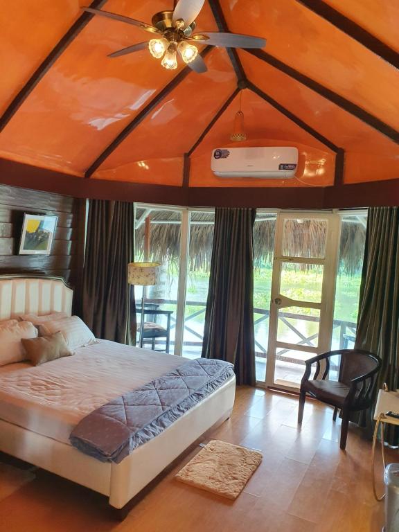 una camera con letto e ventilatore a soffitto di ChitraResort a Narail