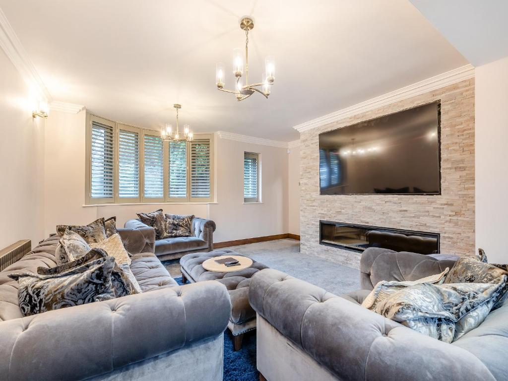 a living room with two couches and a tv at Rock Lodge in Cromford