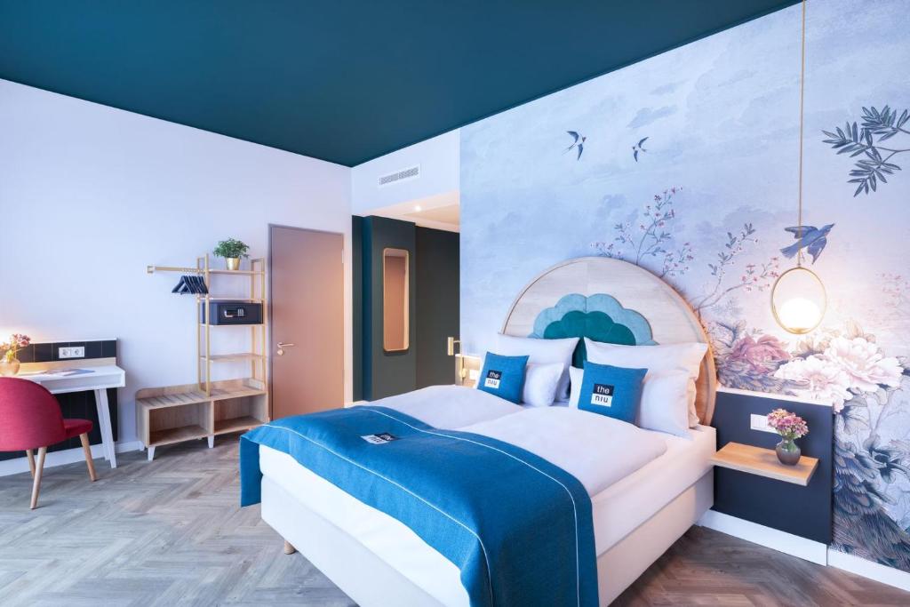 Schlafzimmer mit einem Kingsize-Bett und einem Gemälde an der Wand in der Unterkunft the niu Flower in Konstanz