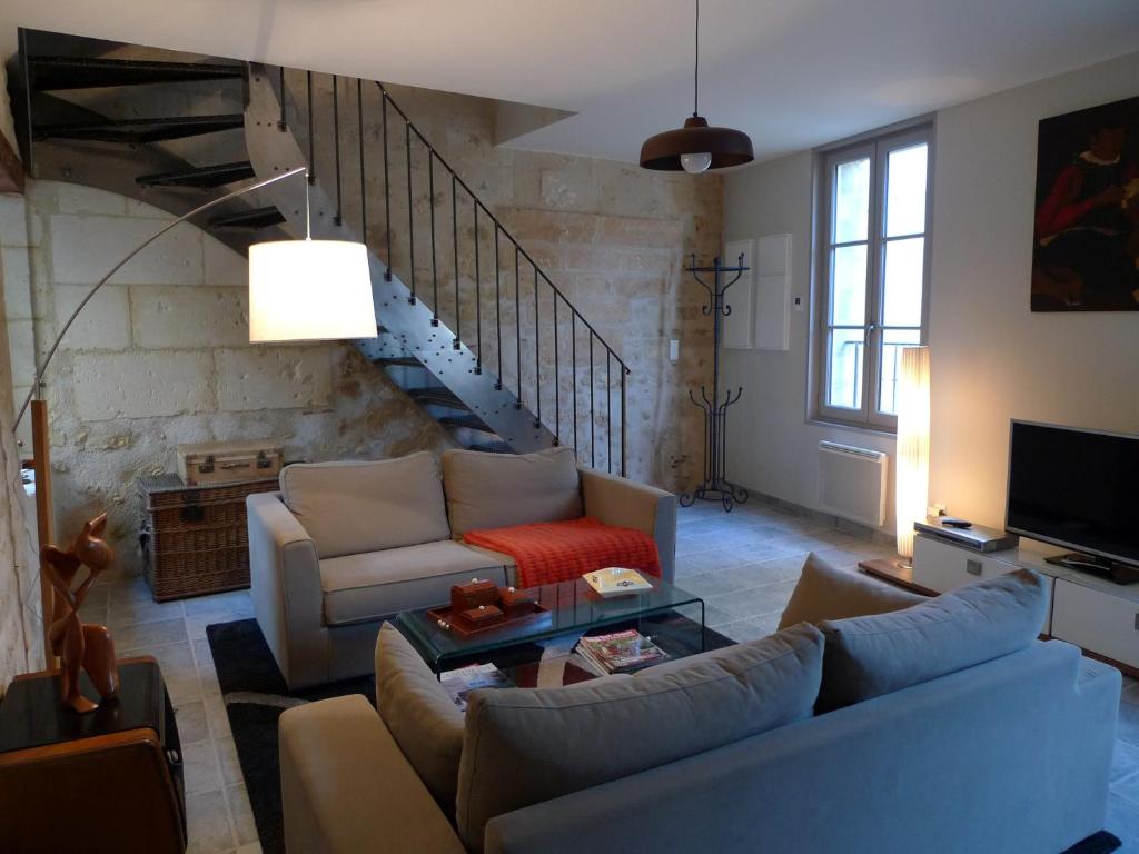 a living room with two couches and a staircase at Gite Nuance in Saint-Aignan
