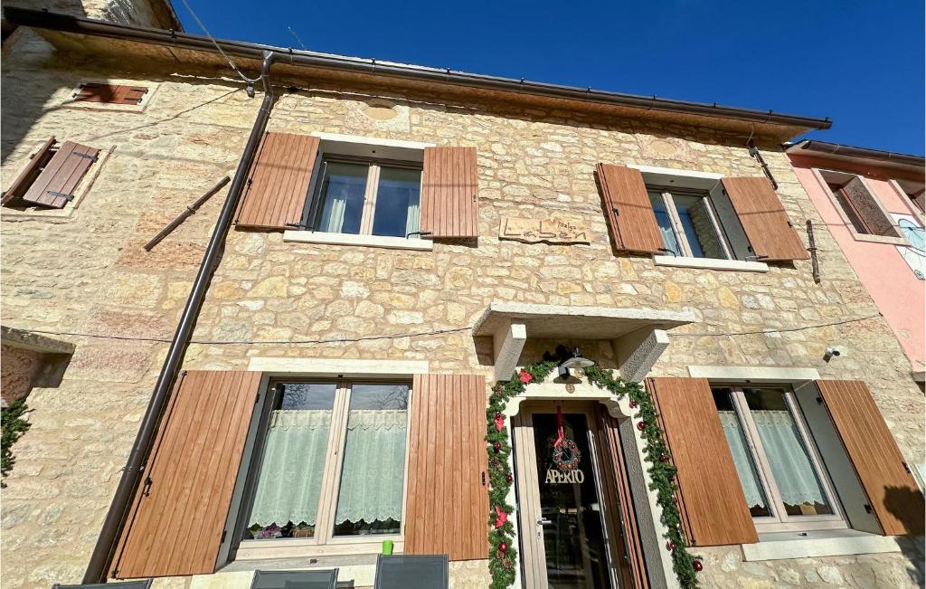 un bâtiment en pierre avec une couronne sur la porte dans l'établissement Stunning Apartment In Velo Veronese With House A Panoramic View, à Velo Veronese